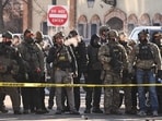 Federal agents stand behind police tape as demonstrators gather where a man was shot and killed by federal agents Federal agents stand behind police tape as demonstrators gather where a man was shot and killed by federal agents