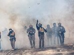A federal agent lobs a teargas canister towards protesters as agents advance through clouds of tear gas during clashes following the fatal shooting of a protester earlier in the day, on January 24, 2026 in Minneapolis, Minnesota. 