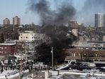 Smoke from burning dumpsters rises during clashes between federal agents and community members at the scene of a shooting on January 24, 2026. REUTERS/Tim Evans