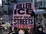 A person holds a placard during clashes between federal agents and community members in Minneapolis, Minnesota, U.S., January 24, 2026. REUTERS/Seth Herald