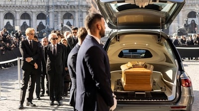 Italian businessman Giancarlo Giammetti and Vernon Bruce Hoeksema follow the coffin of Valentino Gavarani as it arrives at the funeral ceremony.&nbsp; (AFP)