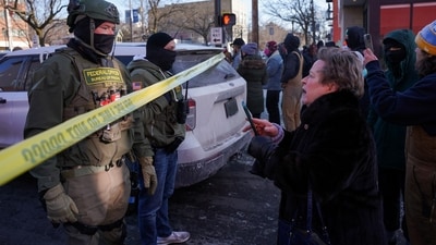 A community member holds a phone as federal agents stand guard at the scene of a shooting involving federal immigration agents, in Whittier neighborhood, in South Minneapolis, Minnesota, U.S., January 24, 2026. REUTERS/Seth Herald (REUTERS)