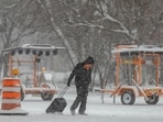 A pedestrian pulls a roller bag through the snow during a snowstorm in Chicago.