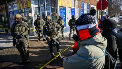Protesters overlook federal agents after they shot a demonstrator dead in Minneapolis on January 24 amid a scuffle to arrest him. The incident fueled nationwide protests. (Brandon Bell/AFP) Protesters overlook federal agents after they shot a demonstrator dead in Minneapolis on January 24 amid a scuffle to arrest him. The incident fueled nationwide protests. (Brandon Bell/AFP)