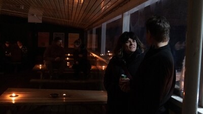 As Greenland's capital Nuuk was left crippled with the outage on Saturday, two people are seen exchanging conversations in a candle-lit environment in a bar in the city. (REUTERS)