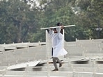 A man protects himself from the rain amid rainfall, in New Delhi on Tuesday