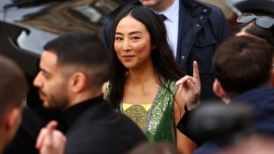 Greta Lee arrives to attend Dior Haute Couture Spring/Summer 2026 show in Paris, France, January 26, 2026. She wore a green metallic top with white trousers. (REUTERS)
