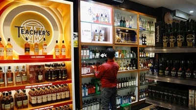 A salesman arranges liquor bottles inside a liquor store in Bengaluru. (REUTERS)