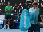 Novak Djokovic, left, of Serbia reacts as Lorenzo Musetti of Italy walks from the court after withdrawing from their quarterfinal match at Australian Open Novak Djokovic, left, of Serbia reacts as Lorenzo Musetti of Italy walks from the court after withdrawing from their quarterfinal match at Australian Open