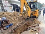 MC team repair the road cave-in at Model Town area in Ludhiana on Tuesday. (Gurpreet Singh/HT)