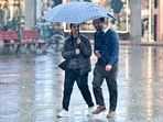 Pedestrians walk through rain during cold winter weather in Chandigarh on Tuesday. (Ravi Kumar/HT)