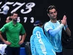Italy's Lorenzo Musetti applauds the fans and walks off the court after retiring from his quarter final match against Serbia's Novak Djokovic.