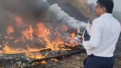 An official stands near the site where Maharashtra Deputy Chief Minister Ajit Pawar's plane crashed in Baramati. (Screengrab/Hindustan Times)
