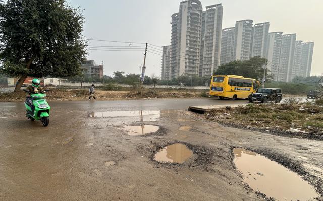 The cratered main road connecting Sector 110 to the Dwarka Expressway near New Palam Vihar Phase 1 as seen on Tuesday. (Parveen Kumar/HT) The cratered main road connecting Sector 110 to the Dwarka Expressway near New Palam Vihar Phase 1 as seen on Tuesday. (Parveen Kumar/HT)