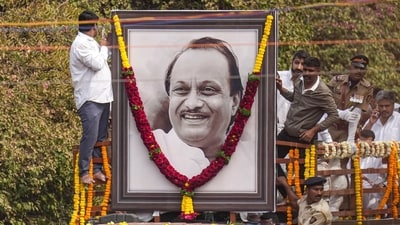 A garland is hung on a portrait of Ajit Pawar when his body were brought to Vidya Pratishthan college ground for his funeral at Baramati on Thursday. (PTI) A garland is hung on a portrait of Ajit Pawar when his body were brought to Vidya Pratishthan college ground for his funeral at Baramati on Thursday. (PTI)