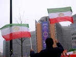 Iran-US tensions highlights: A supporter of the National Council of Resistance of Iran waves pre-1979 Islamic Revolution Iranian flags during a demonstration in support of the Iranian people in front of the European Commission in Brussels.
