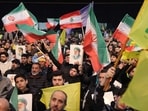 Hezbollah supporters wave Iranian and Lebanese flags while holding portraits of Iran's Supreme Leader Ayatollah Ali Khamenei during a rally to show their solidarity with Iran, in the southern suburb of Beirut on January 26, 2026. (Photo by Anwar AMRO / AFP)