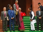 Finance Minister Nirmala Sitharaman, center, displays a red folder containing the Union Budget 2026-27 at the steps of the parliament. (AP Photo)