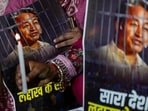 Agitators hold posters and a candle during a protest by AAP over the arrest of climate activist Sonam Wangchuk, at Jantar Mantar, in New Delhi.