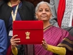 Finance Minister Nirmala Sitharaman shows the digital tablet, enclosed in a traditional red 'bahi-khata' style pouch, at the Parliament.