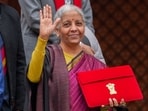 Finance Minister Nirmala Sitharaman shows the digital tablet, enclosed in a traditional red 'bahi-khata' style pouch, at the Parliament premises before presenting of the Union Budget 2026-27, in New Delhi. 