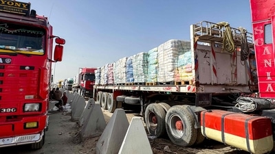 Trucks transporting humanitarian line up outside the Egyptian side waiting to enter Gaza as the crucial border reopens. (AFP)