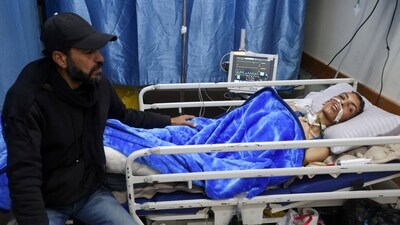Injured Palestinian Ahmed Rasras lies on a hospital bed while waiting for the Rafah Crossing to open to seek treatment abroad, Israel has stated that only 50 patients will be allowed to be transffered per day, enforcing their limited movement guidelines for the crucial border. (REUTERS)