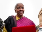 Finance minister Nirmala Sitharaman shows the digital tablet, enclosed in a traditional red 'bahi-khata' style pouch, on the Parliament premises before presenting the Union budget in New Delhi on Sunday. (PTI)