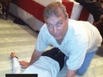 This undated photo shows British former prince Andrew Mountbatten-Windsor kneeling over a woman lying on the floor. 