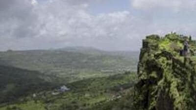 TOPSHOT - In this photo taken on June 30, 2018 visitors walk along the ruins of the Lohagad hill fort, near Lonavla in the western Indian state of Maharashtra. First built upon by Indian dynasties stretching back to the Satavahana Empire around the first century BC, the fortified Lohagad -- meaning Iron Fort -- is based on a flat-top hill in India's Western Ghats mountain range and was still in use by successive empires up until the 1800s. The fort is a popular destination for hikers during the monsoon season when heavy rains brings out fresh foliage in the region. / AFP PHOTO / Alex OGLE (AFP)