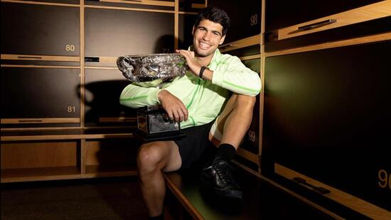 Carlos Alcaraz poses with the Norman Brookes Challenge Cup at the locker room after defeating Novak Djokovic. (AFP)