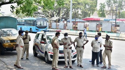 The Bengaluru police stand guard at BMTC bus stand, as coronavirus cases surge in Bengaluru, Wednesday (PTI) The Bengaluru police stand guard at BMTC bus stand, as coronavirus cases surge in Bengaluru, Wednesday (PTI)
