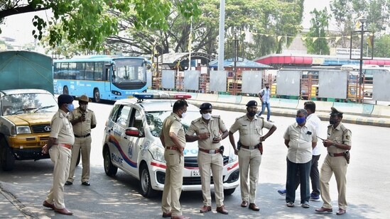 The Bengaluru police stand guard at BMTC bus stand, as coronavirus cases surge in Bengaluru, Wednesday (PTI)
