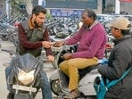 Parking attendants issuing a ticket to a visitor at Feroze Gandhi Market in Ludhiana on Friday. (Manish/HT)