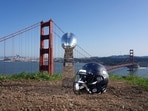A Seattle Seahawks helmet with a Vince Lombardi Super Bowl trophy at the Golden Gate bridge. 