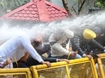 Punjab AAP workers braving water cannons while trying to climb barricades in Chandigarh on Monday. They were prevented from marching to the house of leader of opposition Partap Singh Bajwa to protest against his remarks. (Keshav Singh/HT)
