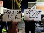 Anti-ICE activists display signs during a protest at the US Immigration and Customs Enforcement (ICE) building in Portland.