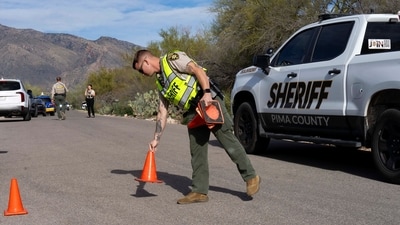 A Pima County Sheriff’s Office deputy sets up a roadblock a few houses down from the home of Nancy Guthrie. (REUTERS)
