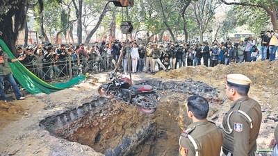 Police retrieve a motorcycle from a large ditch dug by the Delhi Jal Board at Professor Joginder Singh Marg in Janakpuri, where a biker died after falling into the pit. (Vipin Kumar/HT) Police retrieve a motorcycle from a large ditch dug by the Delhi Jal Board at Professor Joginder Singh Marg in Janakpuri, where a biker died after falling into the pit. (Vipin Kumar/HT)