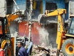 A JCB machine demolishes houses during an anti-encroachment drive at Madhukam near Ratu Road, in Ranchi on Wednesday. (ANI)