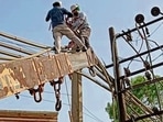 Linemen working on electricity lines in Ludhiana. (HT Photo) Linemen working on electricity lines in Ludhiana. (HT Photo)