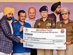 (From left) Punjab chief minister Bhagwant Mann, AAP national convener Arvind Kejriwal and Punjab DGP Gaurav Yadav felicitating police personnel for their role in state government’s anti-drug campaign, during a rally in Moga on Monday. (HT Photo)