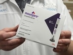 FILE PHOTO: A pharmacist displays a box of Mounjaro, a tirzepatide injection drug used for treating type 2 diabetes. 