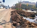 The busy stretch is dotted with sewage-filled pits, creating hazardous conditions for commuters. On Thursday night, a car driver had a close shave after his vehicle plunged into one of the ditches. (HT Photo)