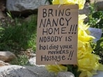 A sign sits in a memorial setup outside of Nancy Guthrie's residence in Tucson, Arizona amid a continued search for the 84-year-old who was reported missing on February 1.