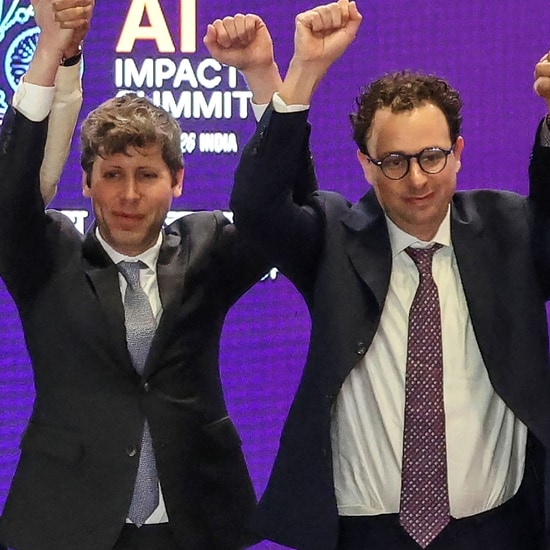 Sam Altman and Dario Amodei raising their hands at the AI Impact Summit