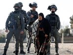 A Palestinian woman, who was denied entry to Jerusalem, walks next to members of Israeli troop, as people make their way to Al-Aqsa compound, also known to Jews as the Temple Mount, in Jerusalem's Old City, to attend the first Friday prayers during the Muslim holy fasting month of Ramadan, near the Qalandia checkpoint in the Israeli-occupied West Bank (REUTERS)
