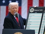 President Donald Trump holds a chart as he delivers remarks on reciprocal tariffs 