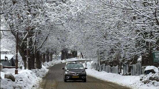 A car moves through a snow-covered area in Pahalgam, Anantnag district, Jammu and Kashmir. (PTI)