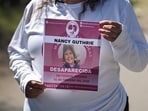 A person holds up a poster amid the ongoing search for Nancy Guthrie. A person holds up a poster amid the ongoing search for Nancy Guthrie.